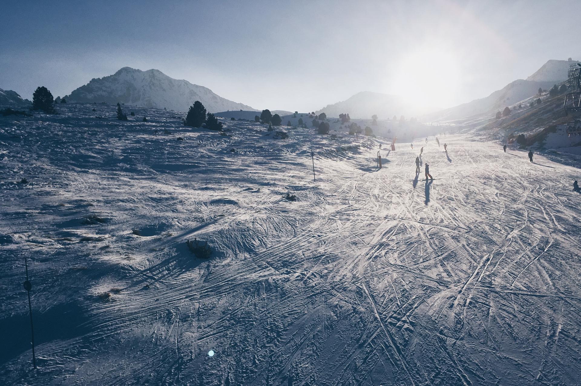 Snowboarders and skiers on gentle ski slope in Andorra ski resort