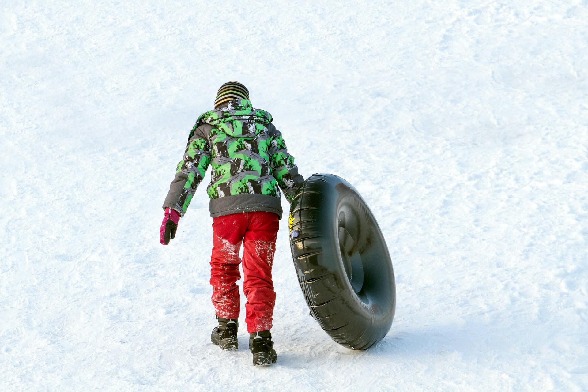 Child carrying tube up the hill
